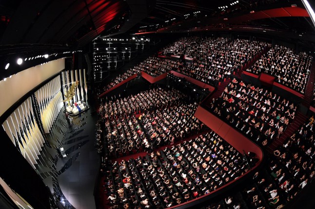 TOPSHOT - A general view shows Japanese director Hirokazu Kore-Eda (L) delivering a speech on stage next to a translator (2ndl), Australian actress and President of the Jury Cate Blanchett (3rdL) and jury members (Rear) after he was awarded with the Palme d'Or for the film "Shoplifters (Manbiki Kazoku)" on May 19, 2018 during the closing ceremony of the 71st edition of the Cannes Film Festival in Cannes, southern France. (Photo by Antonin THUILLIER / AFP) (Photo by ANTONIN THUILLIER/AFP via Getty Images)