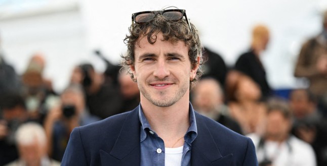 Irish actor Paul Mescal poses in a navy jacket and denim shirt half buttoned over a white vest during a photocall for the film The History of Sound at the 78th edition of the Cannes Film Festival